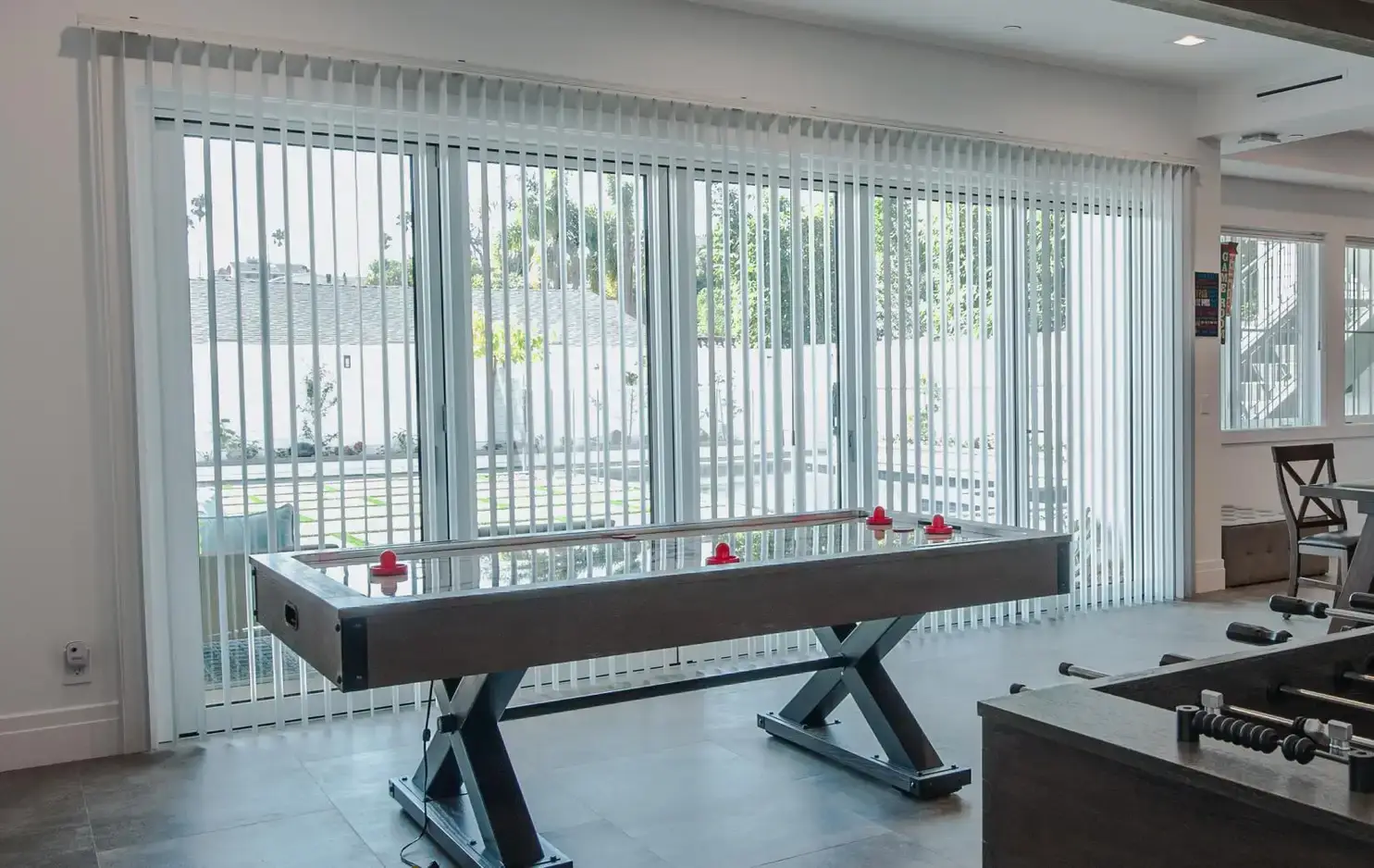 Wide-slat faux-wood blinds covering a sliding glass door